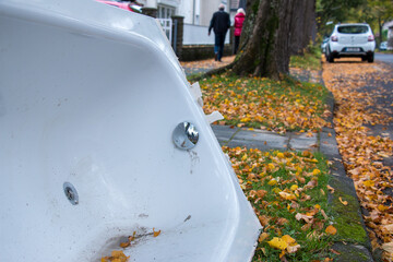 Eine alte Badewanne steht zur Abholung durch den Sperrmüll bereit am Straßenrand