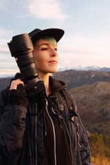 Young photographer with a serene and accommodating gesture, receiving the evening sun on his face...