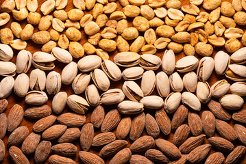 Pattern of pistachios, almonds, peanuts on wood table