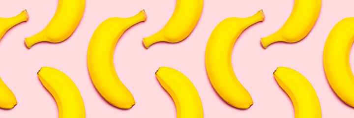 Seamless pattern of bananas on a pink background.