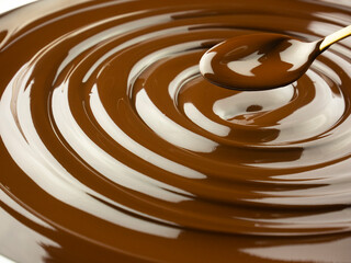 melted dark chocolate spiral with spoon, high quality pastry background master chocolatier