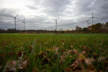 wind farm with agricultural field in the foreground and moody clouds in the background