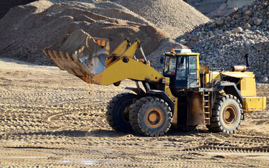 Wheel loader working at the sand open pit. Quarry in which sand and gravel is excavated from the...