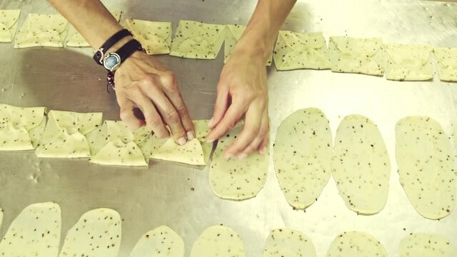 Crop baker shaping flatten dough in kitchen