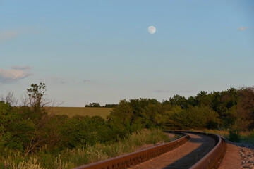 Full moon against sunset, railway, woods, photography