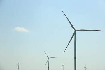 Modern wind turbines against blue sky. Energy efficiency