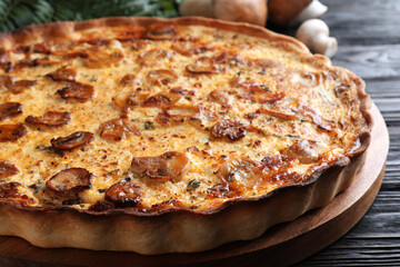 Delicious homemade mushroom pie on black wooden table, closeup