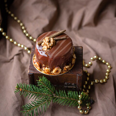 postcard, food photo beautiful delicious small festive New Year's cake with nuts on a brown background, lights, decor, tree