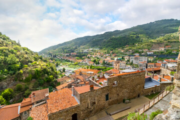 Fototapeta na wymiar View of the Medieval Church of Saint Anthony clock tower and city and valley of Dolceacqua, Italy, from the ancient hilltop castle.