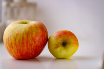 A few ripe apples on a white surface. Rear background is blurred