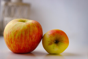 A few ripe apples on a white surface. Rear background is blurred