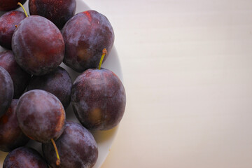Appetizing ripe plums on a white background with copy space