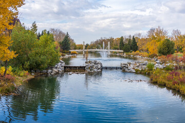 Fototapeta premium Prince's Island Park Jaipur Bridge at Bow river bank. Autumn foliage scenery in downtown Calgary, Alberta, Canada.