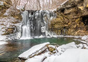 Hayden Run Falls, a secluded waterfall in Columbus, Ohio, is surrounded by winter snow with icicles freezing on rock walls.