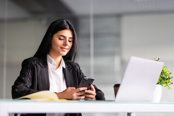 Young businesswoman using smart mobile phone and laptop computer with screen blank on desk, Young woman use device internet for working, Business and education concept.