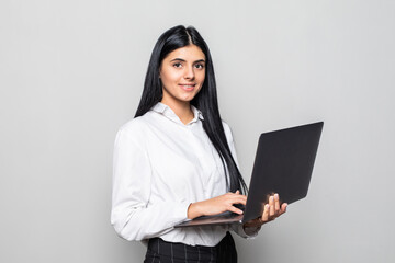 Successful business woman is standing with laptop on white background.