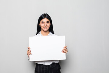 Happy smiling young business woman showing blank signboard on white background