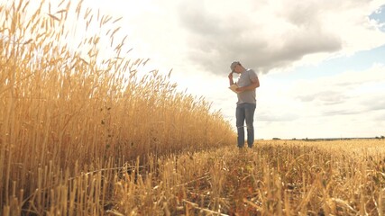 farmer working with tablet computer on wheat field. agricultural business. businessman analyzing grain harvest. agronomist with tablet studying wheat harvest in the field. grain harvest. ecologically