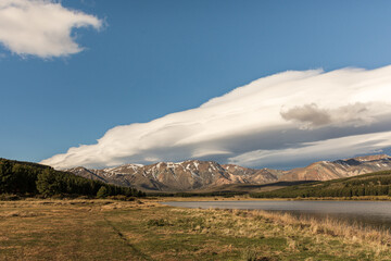 Fototapeta premium Landscape view of lenticular clouds over the lake during afternoon in Esquel, Patagonia, Argentina