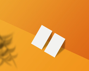 White blank business cards on 3D orange space, usable for mockup purposes.