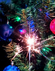 Obraz na płótnie Canvas New Year's sparkler near the Christmas tree