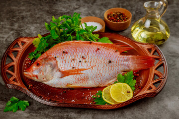 Red tilapia fish with herbs, spices and olive oil.