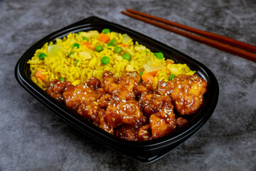 Teriyaki chicken with rice and vegetables in plastic food container.