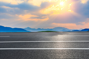 Asphalt road and mountain at sunset.Road and mountain background.
