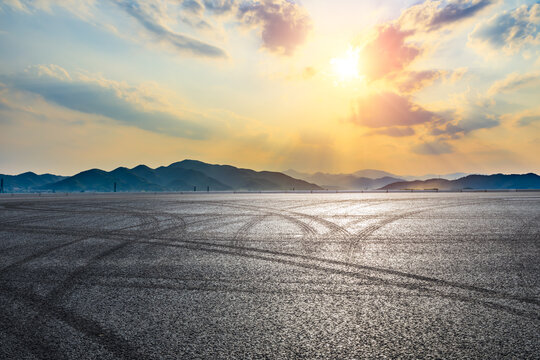 Asphalt road ground and mountain at sunset.Race track road and mountain background.