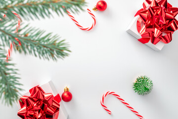 Happy new year. White gifts with scarlet bow, red balls and sparkling lights in xmas decoration on white background for greeting card. Christmas, winter, new year concept.
