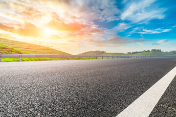 Naklejka premium Asphalt road and mountain with tea plantation at sunset.Road and mountain background.