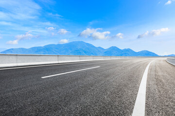 Asphalt road and green mountain under blue sky.Road and mountain background.