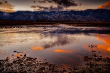 Landscape image of a sunset with mountains in the background.