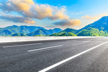 Asphalt road and mountain at sunset.Road and mountain background.