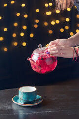 red tea with berries is poured into a blue cup