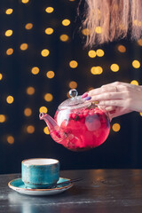 red tea with berries is poured into a blue cup