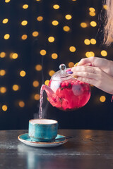 red tea with berries is poured into a blue cup