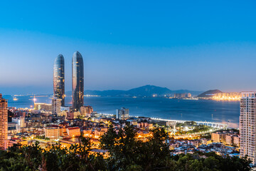Night coastline scenery of twin towers and Yanwu bridge in Xiamen, Fujian, China