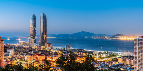 Night coastline scenery of twin towers and Yanwu bridge in Xiamen, Fujian, China