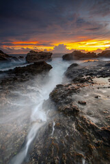 Beach sunset with rock foreground at Sawarna Beach no people