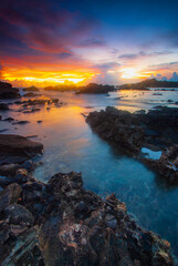 Obraz premium Beach sunset with rock foreground at Sawarna Beach no people