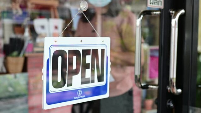Asian woman wearing face mask while attaching business closed sign at door shop entrance due from coronavirus covid-19 epidemic outbreak over the world 2nd
