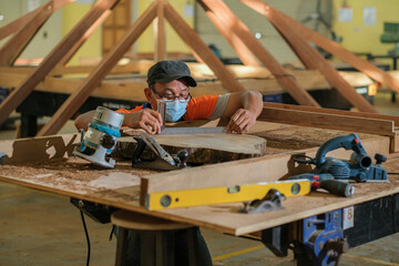 Front view photo of focused professional hardwood worker making slab coffee table use try square to...