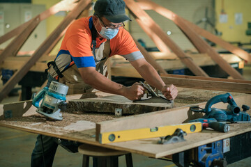 Front view photo of focused professional hardwood worker making slab coffee table use hand...