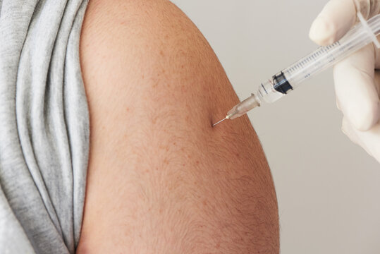 A doctor injecting  vaccine at patient arm