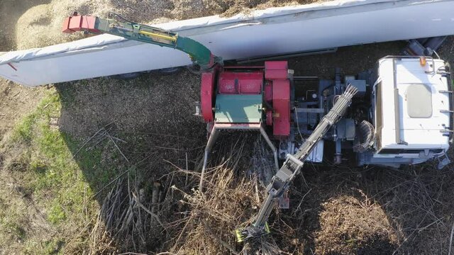Wood Chipper Blowing Shredded Wood Into Back Of A Truck. Aerial Pedestal Down