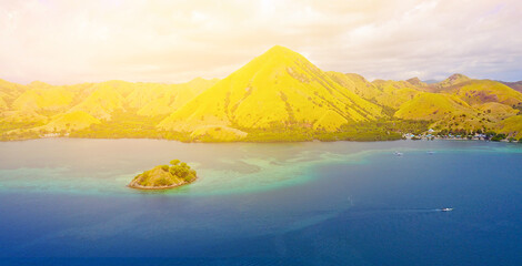 Beautiful aerial view of beaches and tourist boat sailing in Flores Island, Indonesia.