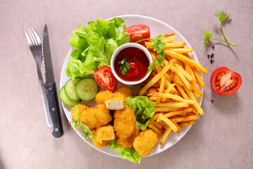 plate with chicken nugget, french fries and vegetable salad