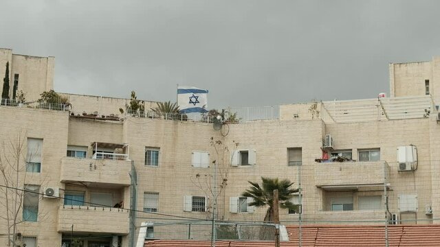 An Israeli flag is fluttering in the wind over a questionable Israeli settlement in the middle of a Palestinian neighborhood at East Jerusalem.