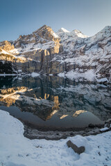 Dans les alpes suisses, photos d'un lac de montagnes avec la neige et des reflets.